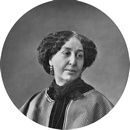 Portrait en noir et blanc d'une femme aux cheveux bouclés, portant une robe sombre et un châle, et regardant légèrement vers la droite. Portrait en noir et blanc d'une femme aux cheveux bouclés, portant une robe sombre et un châle, et regardant légèrement vers la droite.